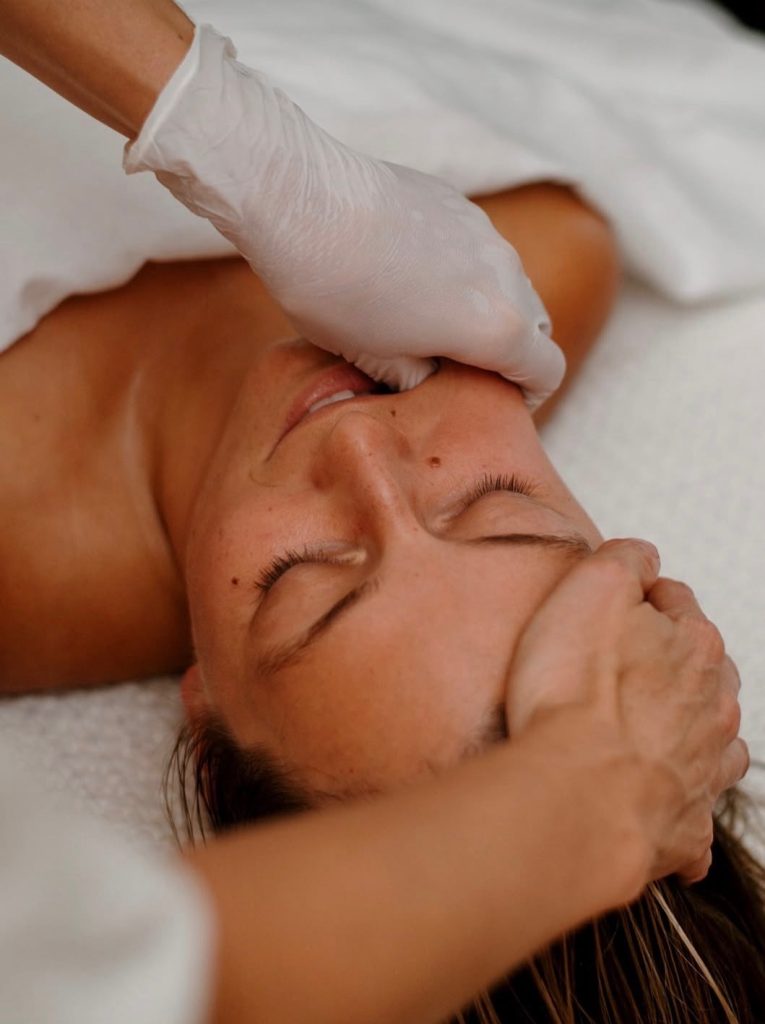 A client receiving a rejuvenating buccal facial massage, focusing on relaxing deep jaw tension for a, sculpted, radiant look